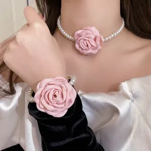 Close-up of elegant French style pearl necklace and bracelet set with pink fabric roses