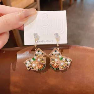 Détail de boucles d'oreilles nœud avec cristaux roses et petites perles blanches