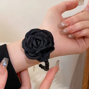 Close-up of elegant black fabric rose bracelet with stylish beaded details