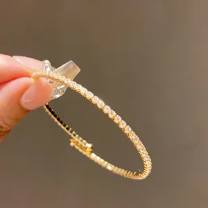 Vue détaillée d'un élégant jonc doré orné de zircons scintillants pour femmes