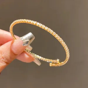 Gros plan d'un jonc ouvert doré élégant avec des pierres de zircone cubique scintillantes.