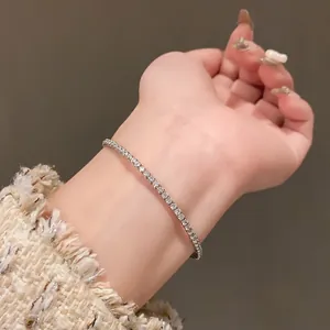 Gros plan d'un élégant bracelet tennis en argent avec zircons sur un poignet.