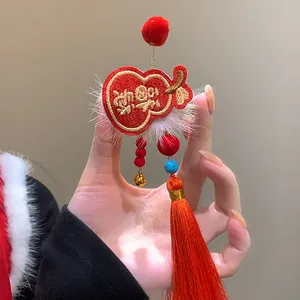 Macro view showing details of festive red New Year hair clip with tassel and bell