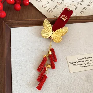 Close-up of festive red velvet hair clip with gold butterfly and Wealth character detail