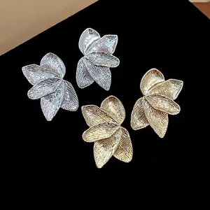 Elegant textured flower petal stud earrings set in minimalist gold and silver finishes