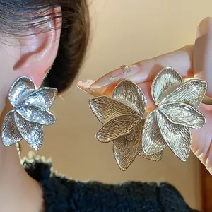 Macro detail of elegant gold floral petal textured stud earrings for women fashion