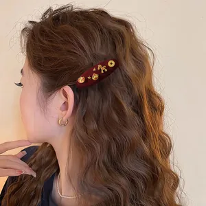 Close-up detail of a festive red flocked hair clip featuring golden lion and coin charms
