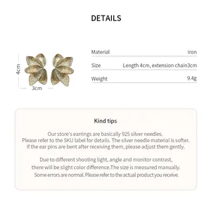 Macro view of gold flower petal stud earrings showing intricate textured surface details