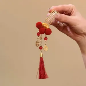 Detailed view of traditional Chinese red hair comb with gold ingot and elegant tassel
