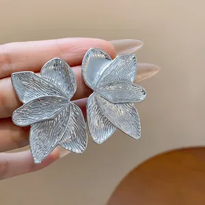 Close-up of silver petal textured earrings with detailed metallic finish for women