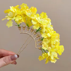 Detailed macro shot of a yellow fabric flower hairpin with a gold U-shaped metal base