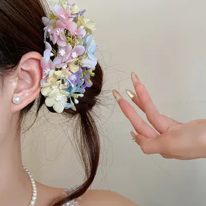 Detailed view of the multi-colored pastel fabric flower hair pin styled in a bun