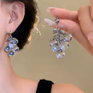 Detail view showing transparent crystal grape earrings with elegant silver needle