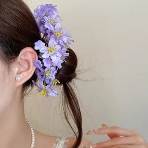 Detailed view of a model wearing an elegant purple fabric flower hair pin accessory.