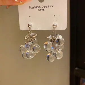 Close-up of crystal grape drop earrings with silver needle on white jewelry display card