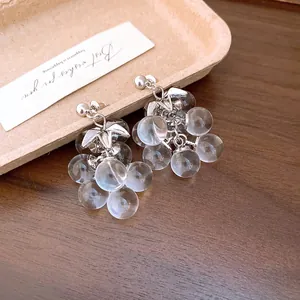 Close-up of crystal grape tassel earrings with clear beads and silver leaves.