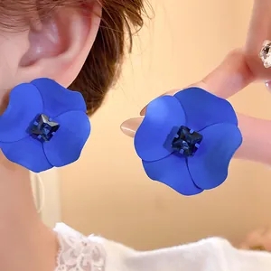 Close-up detail of vintage blue painted flower earrings with dark crystal center.