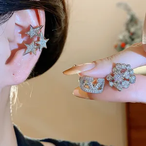 Primo piano di polsini per orecchie in zircone con disegni di stelle e logo per orecchie senza buchi.