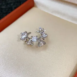Primo piano dettagliato di un ear cuff argento con grappoli di zirconi scintillanti.