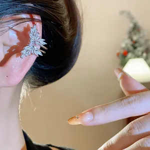Dettaglio ravvicinato di un ear cuff a farfalla con zirconi su un orecchio femminile
