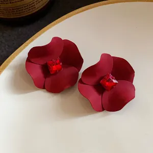 Detailed close-up of vintage red flower stud earrings with a central red crystal