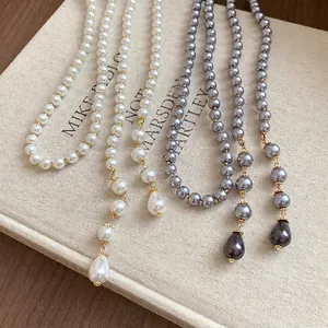 Elegant vintage multi-layer pearl necklace featuring teardrop pendants in white and grey.