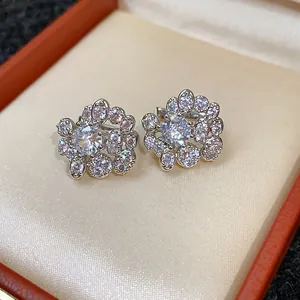 Primo piano di orecchini a fiore in argento con brillanti pietre di zirconi bianchi