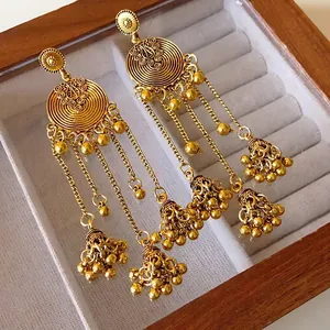 Vintage ethnic style golden tassel earrings with round flower motif in a jewelry box