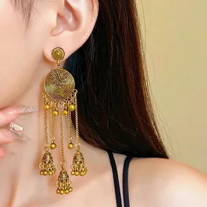 Vintage ethnic gold-tone round flower tassel earrings worn by a model