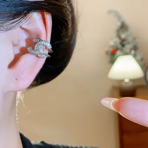 Vista dettagliata di un lussuoso ear cuff a forma di doppia C con zirconi incastonati