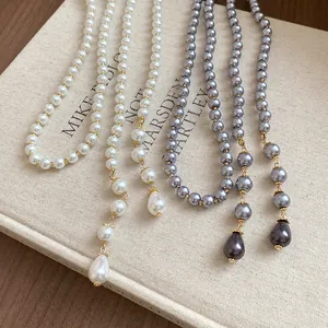 Close-up of elegant multi-layer vintage pearl necklaces with decorative drop pendants.