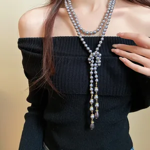 Close-up of elegant grey multi-layer pearl necklace with golden teardrop accents