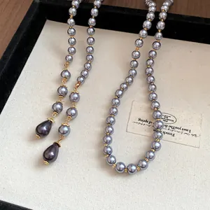 Macro detail view of high-end vintage grey pearl necklace with elegant golden spacers beads