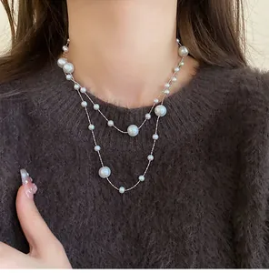 Detail view of an elegant double-layered irregular pearl necklace on a model's neck