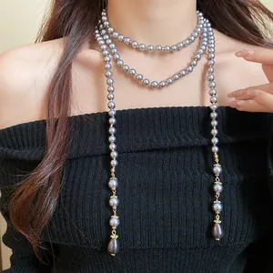 Close-up of elegant multi-layered grey pearl necklace with gold hardware and drop pendants