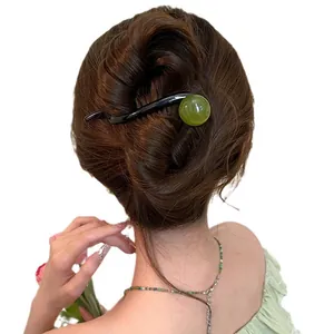 Korean minimalist resin hair clip with green bead on an elegant brown bun hairstyle