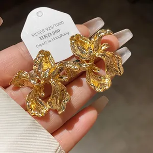 Detailed macro view of golden vintage textured iris flower earrings with 925 silver needle