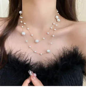 Close-up of double-layer necklace with irregular white pearls and delicate gold chain