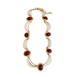 Vintage gold-tone necklace featuring oval red gemstones and retro palace style design