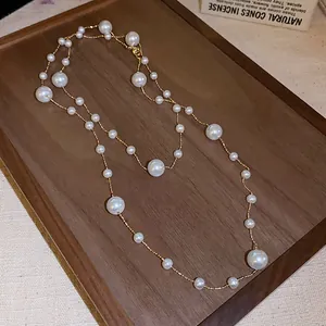 Elegant French retro irregular pearl necklace with delicate gold chain on a wooden tray display.
