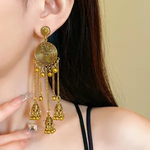 Detailed view of ethnic golden fringe earrings with floral base and jhumka tassels