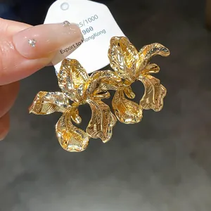 Close-up showing the intricate texture of gold iris flower earrings with vintage finish