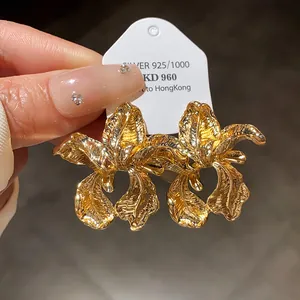 Close-up of vintage gold flower earrings with silver needles and textured petals