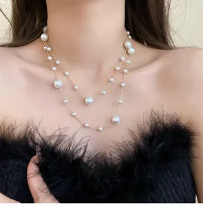 Detail showing elegant double-layer faux pearl necklace on model's neck