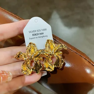 Macro detail view of vintage gold iris flower earrings with 925 silver needle post
