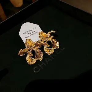 Close-up view of vintage 925 silver irregular floral earrings with textured gold finish.