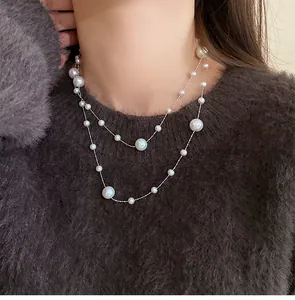 Close-up of elegant double-layered pearl necklace with irregular beads on a fuzzy brown sweater.
