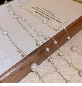 Close-up of elegant irregular pearl necklaces with gold and silver chains on display