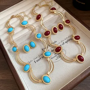 Macro view of vintage gold-tone necklaces featuring blue and red oval gemstones