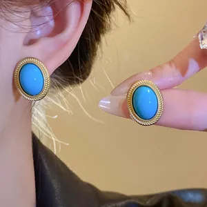 Vintage palace style earrings with oval blue gemstone and textured gold rope border